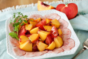 A spicy twist on peach and tomato salad. I make my dressing with lime juice and fresh ginger over ripe peaches and tomatoes