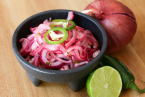 Quick pickled red onions with lime juice, salt, oregano and jalapeños makes a simple taco condiment