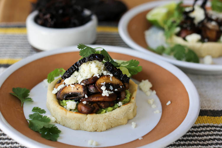 Vegetarian sopes with guacamole, sauteed mushrooms, crisp fried ancho chile strips and cotija cheese. Easily converts to a vegan sopes recipe, too! Sopes are a thick corn tortilla shell filled with anything you like and they make an easy weeknight meal.