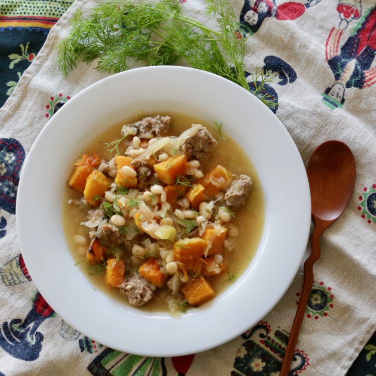 Bratwurst stew with navy beans and roasted butternut squash garnished with fresh dill