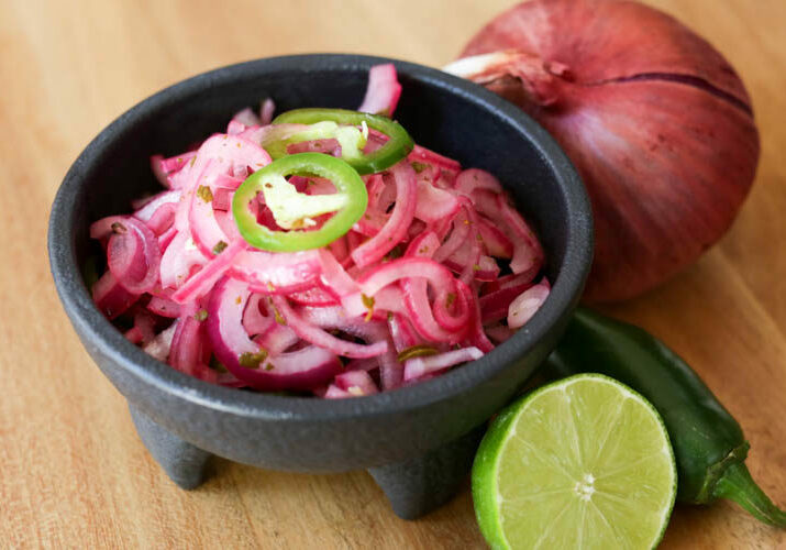 Quick pickled red onions with lime juice, salt, oregano and jalapeños makes a simple taco condiment