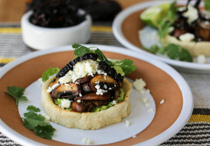 Vegetarian sopes with guacamole, sauteed mushrooms, crisp fried ancho chile strips and cotija cheese. Easily converts to a vegan sopes recipe, too! Sopes are a thick corn tortilla shell filled with anything you like and they make an easy weeknight meal.